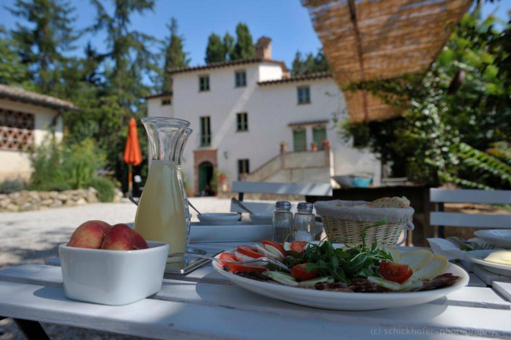 einen Tisch mit einem Teller Essen und einer Schale Obst in der Unterkunft L'Ariete in Montone