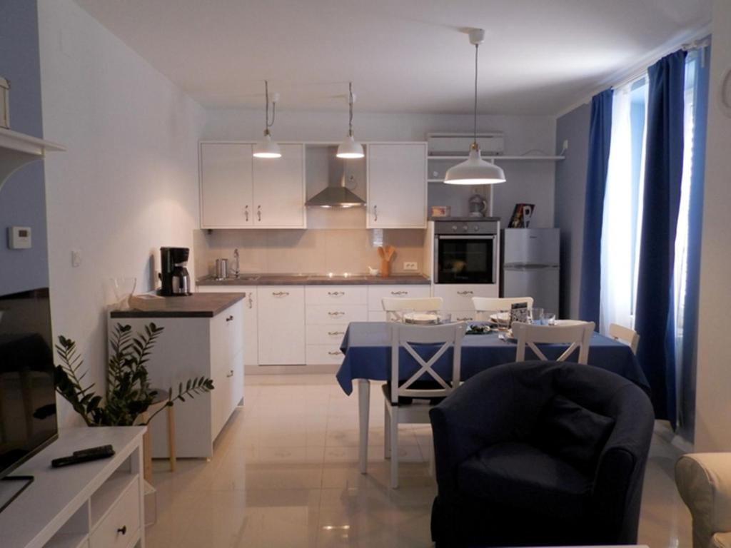 uma cozinha e sala de jantar com mesa e cadeiras em Apartment Kiki Candy em Malinska