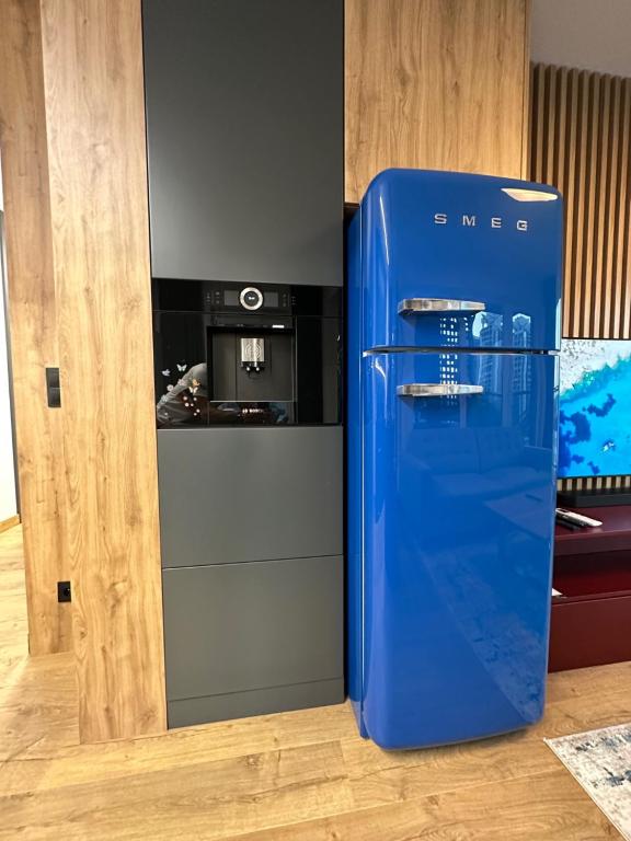 a blue refrigerator in a kitchen with a stove at 8Flor Sokolska 30 Katowice in Katowice