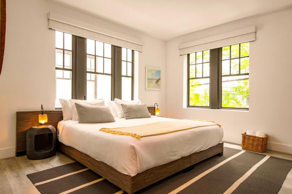 a bedroom with a large bed with two windows at Casa Sofi in Miami Beach