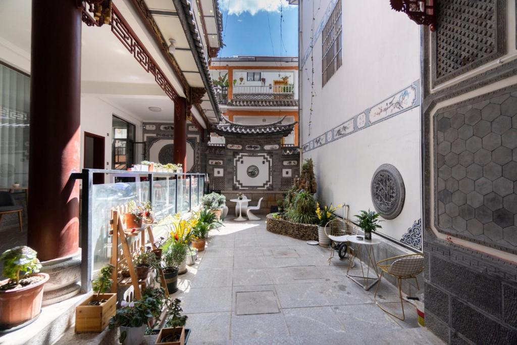 a hallway with potted plants in a building at Dali Ancient City Xinyu Xuan B&B - Erhai Gate Branch in Dali