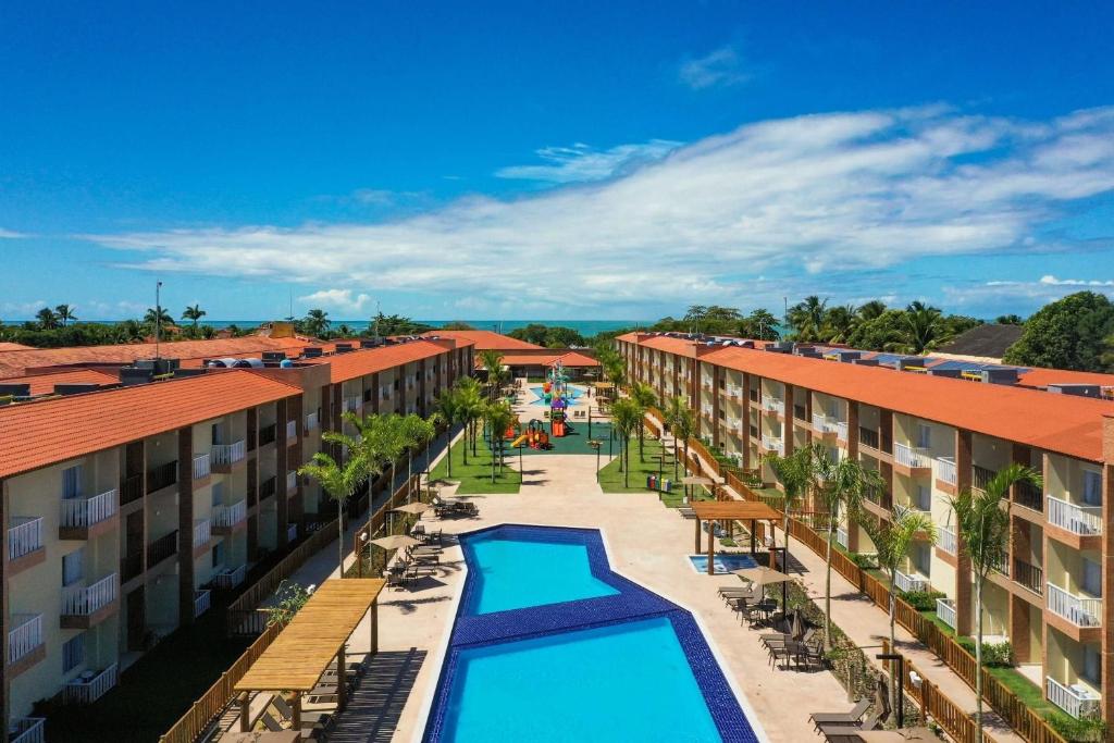 ポルト・セグロにあるOndas Praia Resort - MCのプール2つ付きのリゾートの中庭を一望できます。