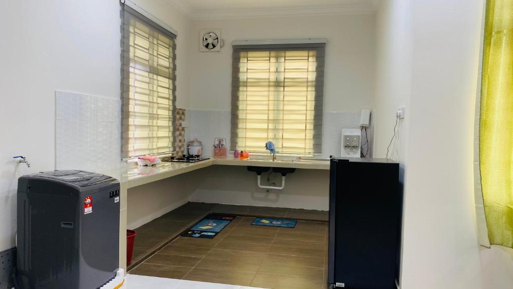 - une cuisine avec un évier et un bureau dans la chambre dans l'établissement Kaklah Cherang Homestay, à Kota Bharu