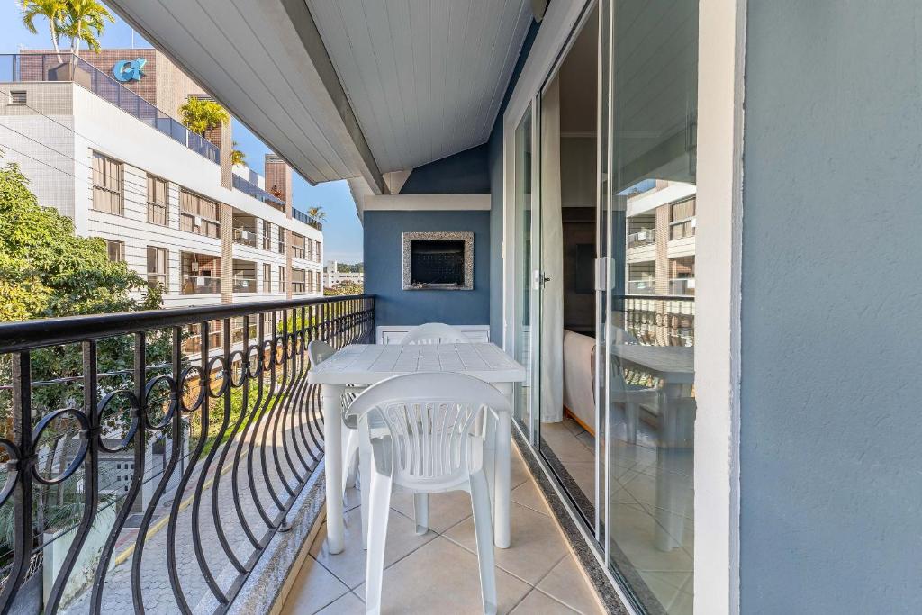 a balcony with a white table and chairs on it at Excelente Apartamento 190m da Praia de bombinhas - 3 dorms 6 pessoas in Bombinhas