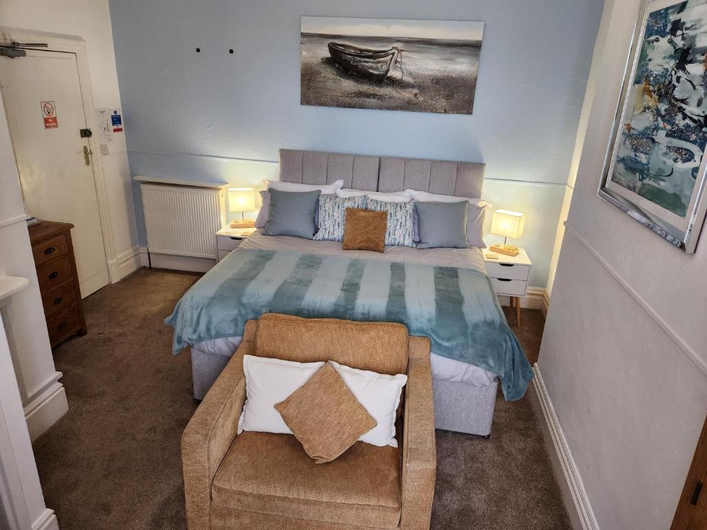 a bedroom with a bed and a chair in it at The Sea Croft Bed Breakfast & Bar in Lytham St Annes