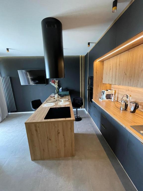 a kitchen with a wooden island with a sink at Apartament w Ełku 52m in Ełk