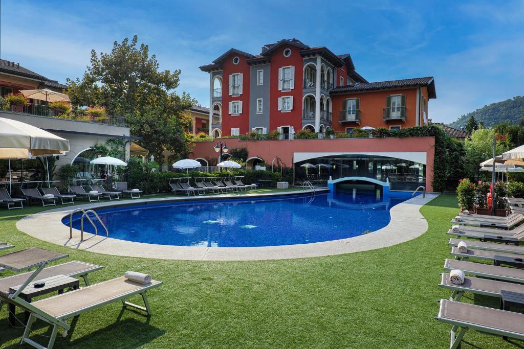 a hotel with a swimming pool in a yard at Aquazzurra Resort & Aparthotel in Cannobio