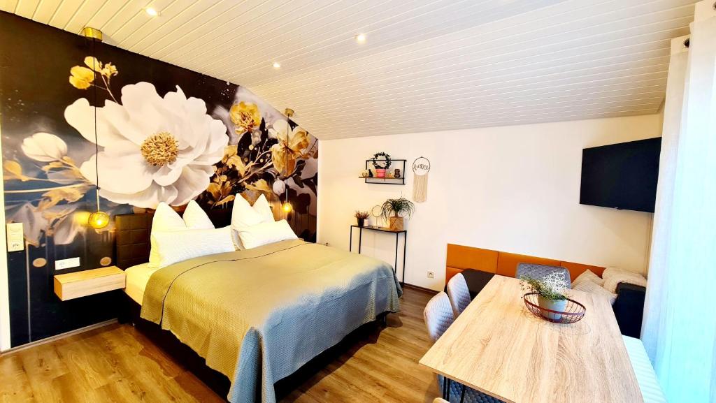1 dormitorio con 1 cama y una pintura floral en la pared en Ferienwohnungen Krüger ''Apartment Finn", en Michelstadt