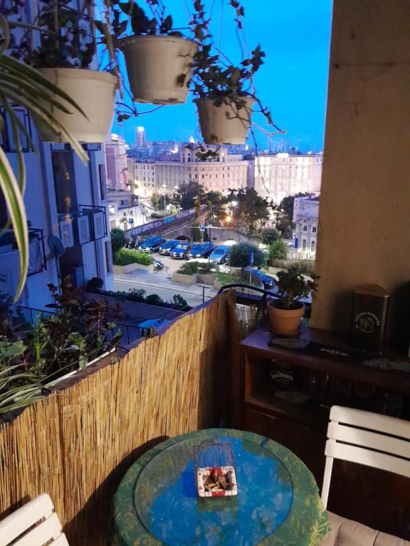 a table on a balcony with a view of a city at Stanza con vista P. Principe in Genova