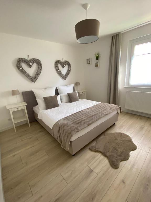 ein Schlafzimmer mit einem Bett und zwei Herzen an der Wand in der Unterkunft Harzperle 1 II zentrales 3 Zi Apartment II Familien in Bad Harzburg