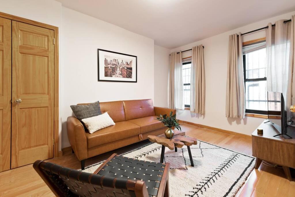 un soggiorno con divano e tavolo di Delightful 2BR Apartment in NYC! a New York