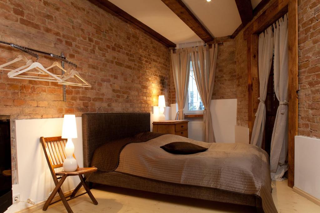 a bedroom with a bed and a brick wall at Smart Appart Blücher Berlin in Berlin