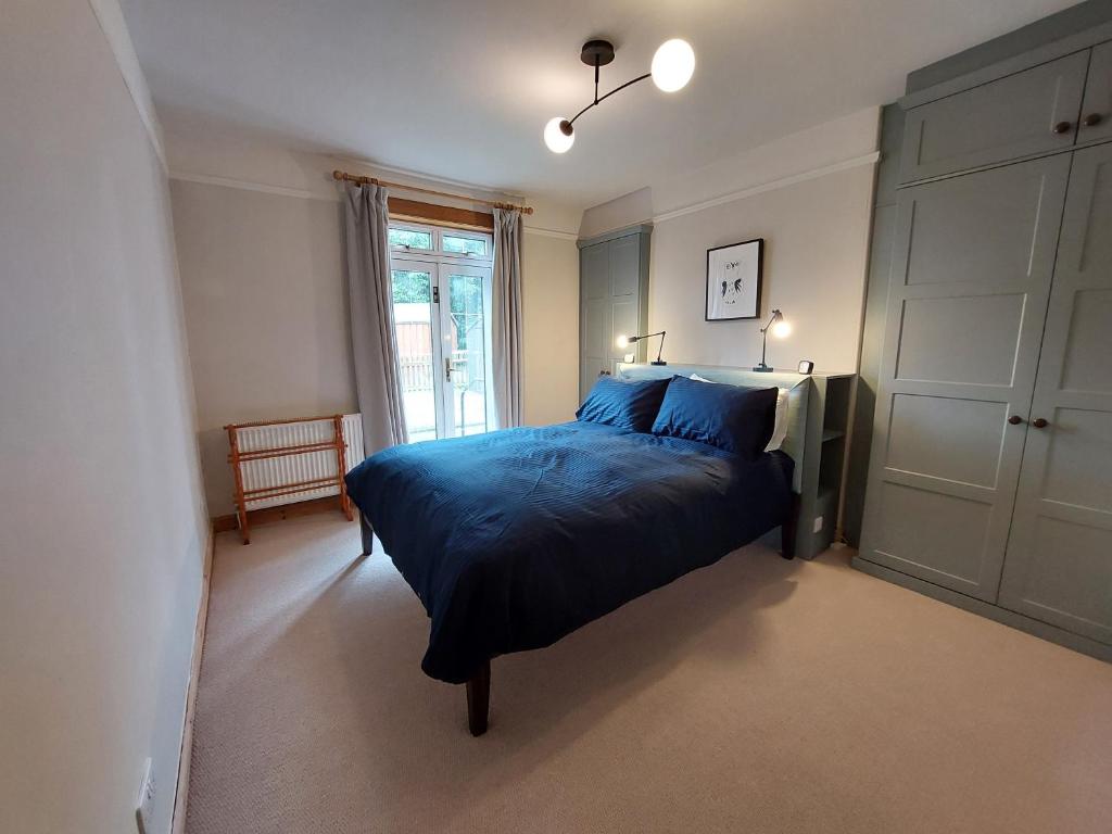 a bedroom with a bed with blue sheets and a window at Cosy flat in Innerleithen in Innerleithen