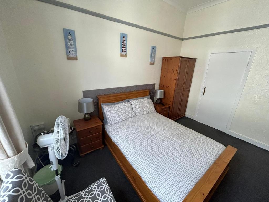 a small bedroom with a bed and a fan at The Little Emily - Room Only in Great Yarmouth