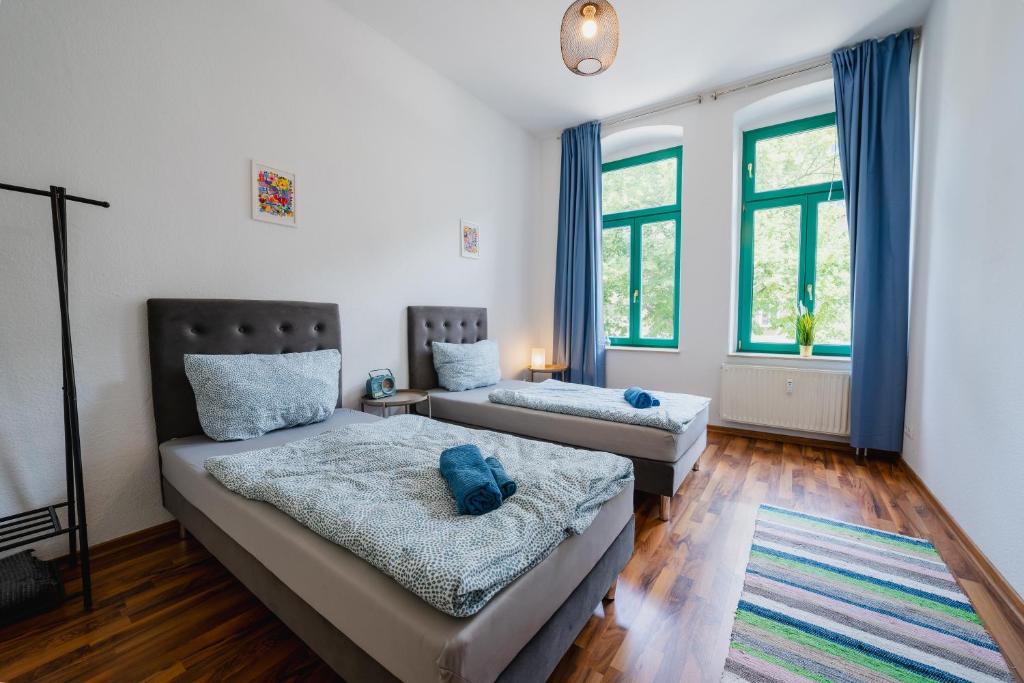 1 Schlafzimmer mit 2 Betten und 2 Fenstern in der Unterkunft Blue Chili 04 - MD Top City Apartment - WiFi in Magdeburg