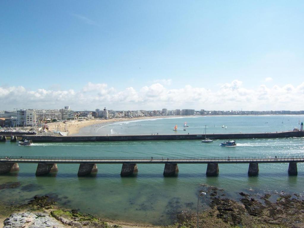 un pont sur une étendue d'eau avec une plage dans l'établissement Appartement avec vue sur le chenal, garage et wifi - FR-1-197-139, à Les Sables-dʼOlonne