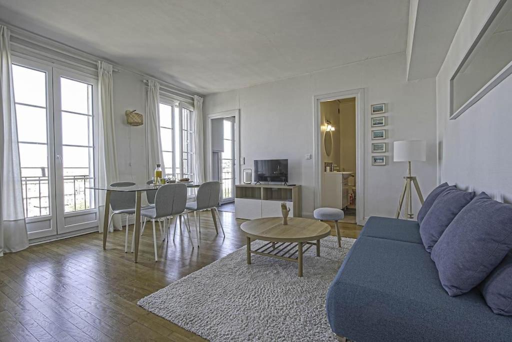 uma sala de estar com um sofá e uma mesa em F2 immeuble Perret avec vue à 180 ° sur la ville - Parking privatif - Hypercentre em Le Havre