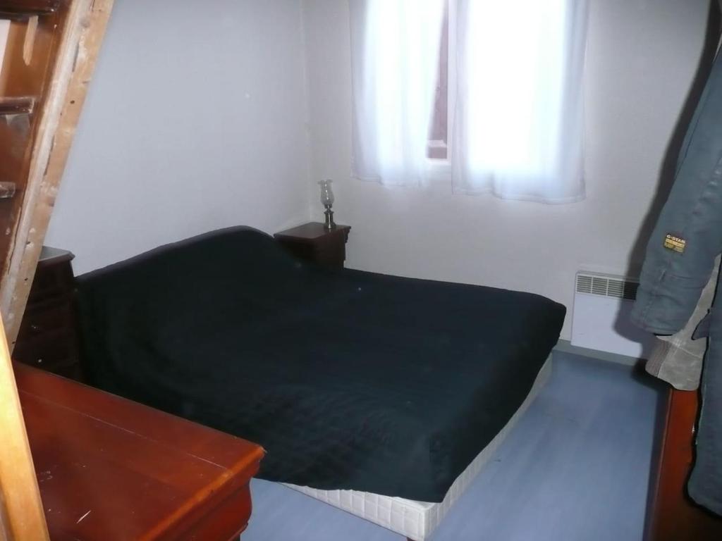 ein kleines Schlafzimmer mit einem grünen Bett und einem Fenster in der Unterkunft 0170 m de la plage in La Ciotat