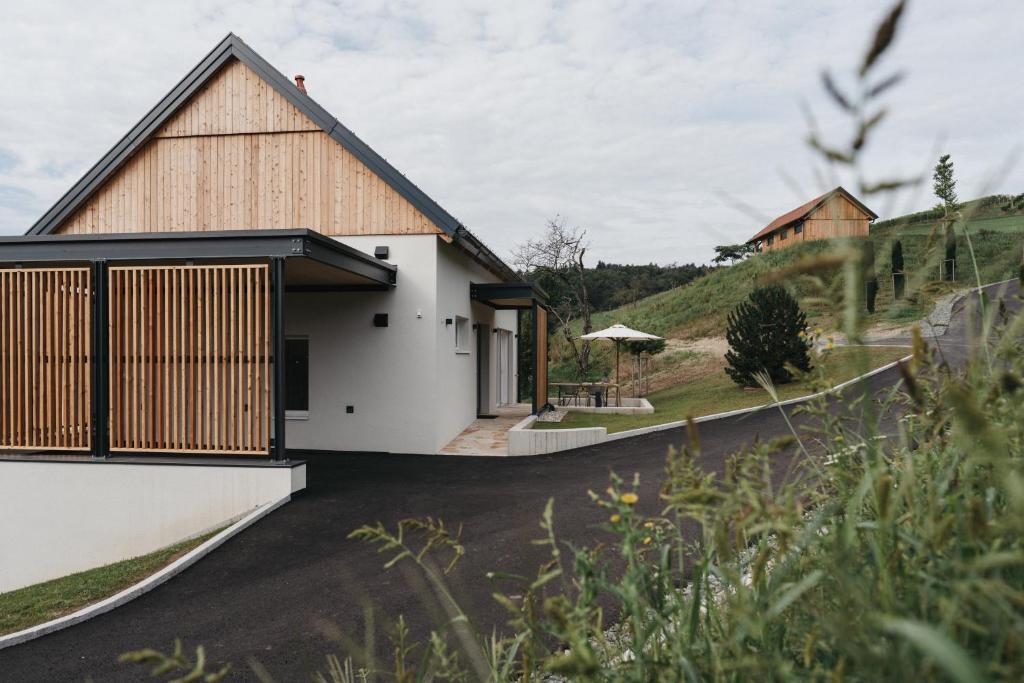a house on a hillside with a white facade at Das Dietrich - Landhaus 64 in Leibnitz