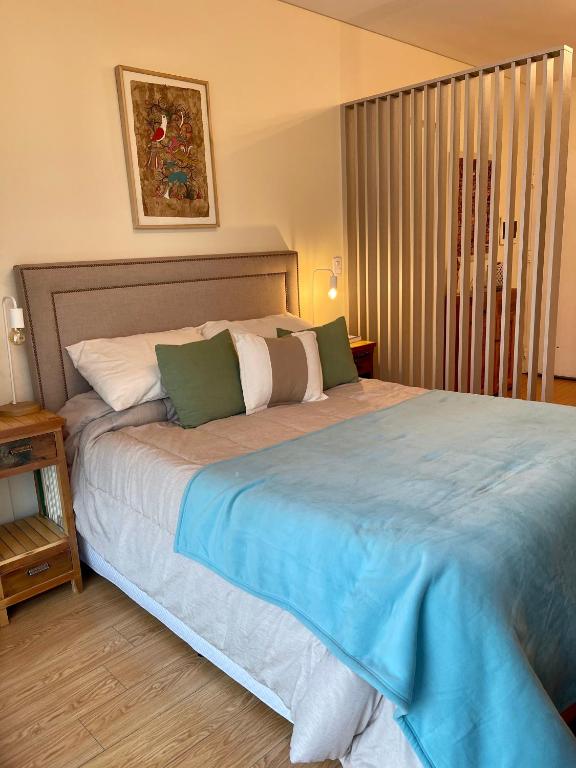 1 dormitorio con 1 cama grande con manta azul en Palermo en Buenos Aires