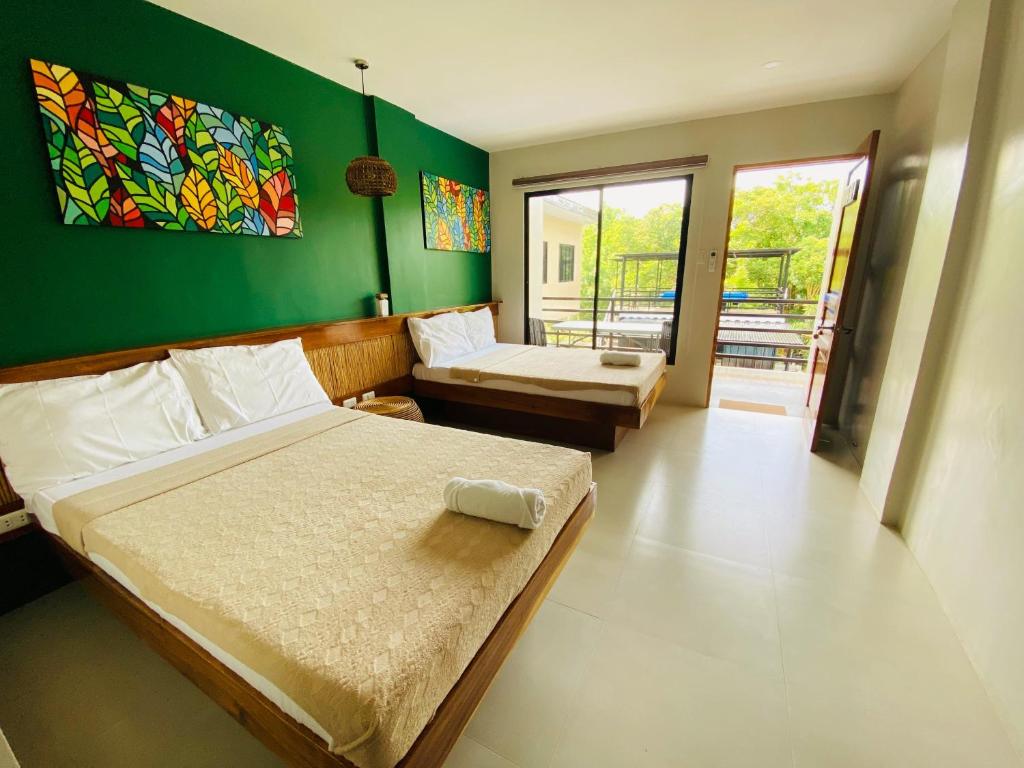 1 Schlafzimmer mit 2 Betten und einer grünen Wand in der Unterkunft TEZA Resort in Bantayan
