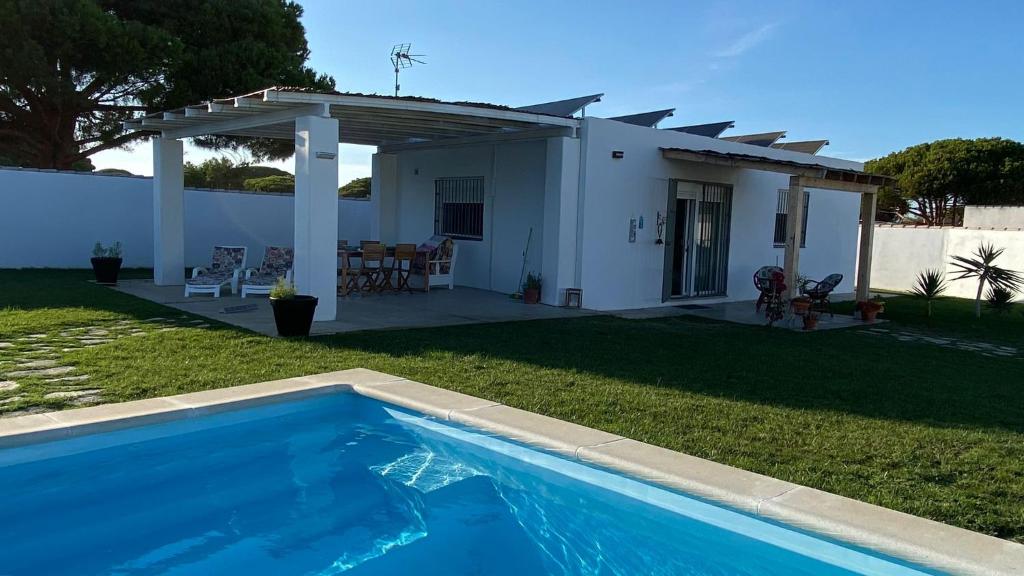 a villa with a swimming pool in front of a house at Casa Costa Ecologica y de Design con Piscina, Jardin y Parking in Chiclana de la Frontera