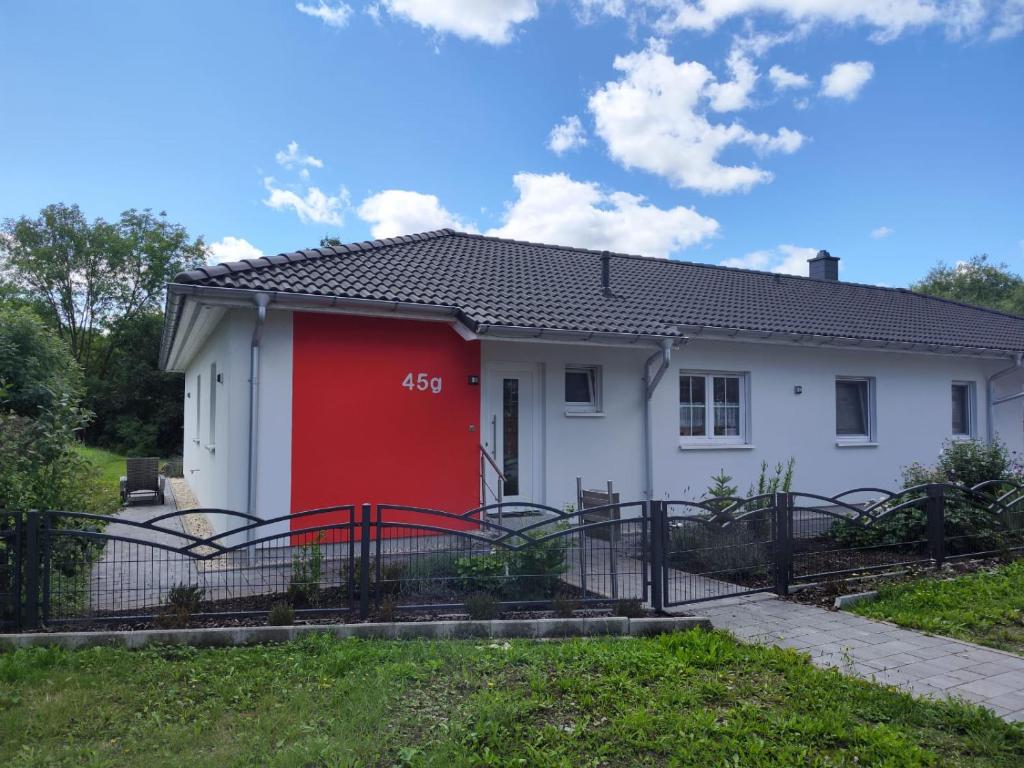 a white house with a red door at Ferienhaus Kleine Auszeit in Creuzburg
