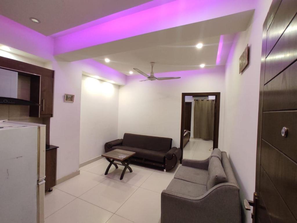 een woonkamer met een bank en een tafel bij New & elegant 1BR Flat for Families,tourists,4k Netflix,wifi,E11 Markaz in Islamabad
