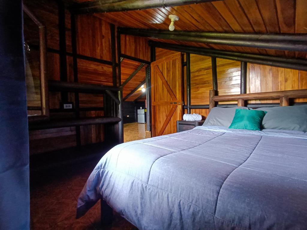 Palmares的住宿－Cabañas San Rafael，小木屋内一间卧室,配有一张大床