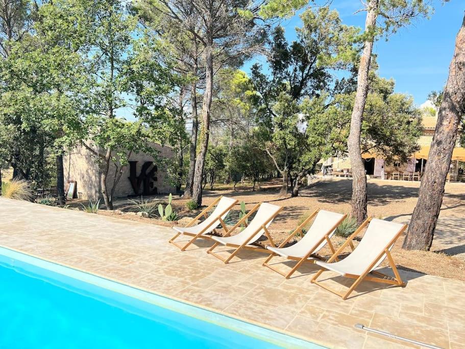 un groupe de chaises longues assises à côté d'une piscine dans l'établissement Villa Piscine Vue exceptionnelle, à Murs