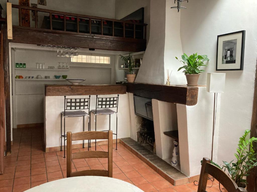 uma cozinha com lareira, 2 cadeiras e uma mesa em Le Cardinale - Un Voyage en Provence - 2 chambres avec parking em Aix-en-Provence