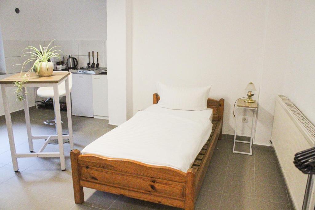 1 dormitorio con cama, mesa y cocina en Ferienhaus Seilerbahn 17, en Vallendar