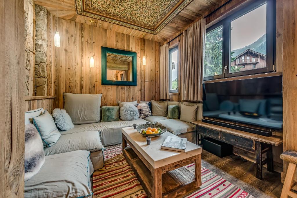 a living room with a couch and a television at Appartement FORNET à l'Hôtel LE VAL D'ISERE in Val dʼIsère