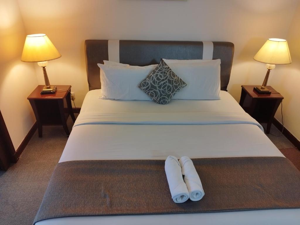 a hotel room with a bed with two towels on it at Bintang Royal Casa Suites Times Square KL in Kuala Lumpur
