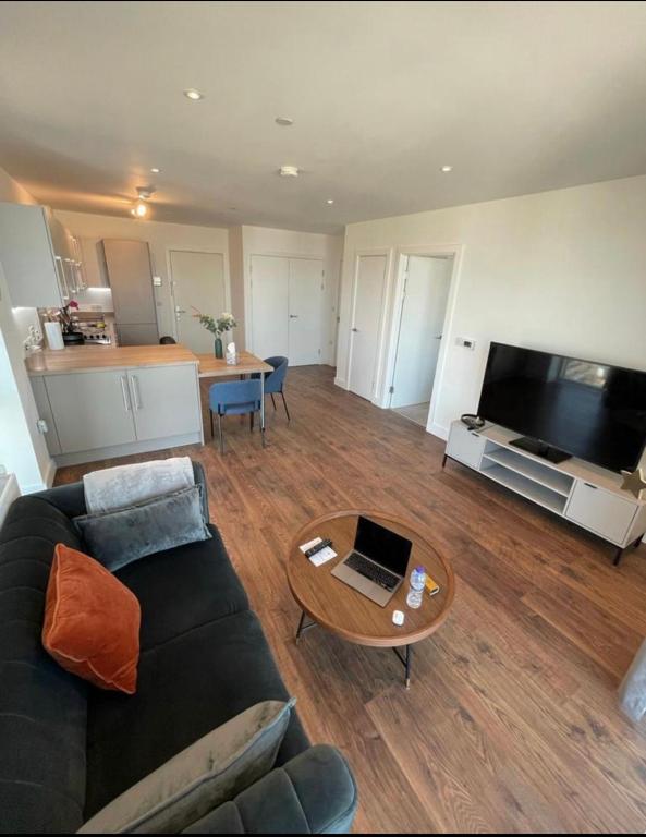 sala de estar con sofá y mesa en Modern New Airy 1 Bed Apartment LONDON cosy stays en Barking