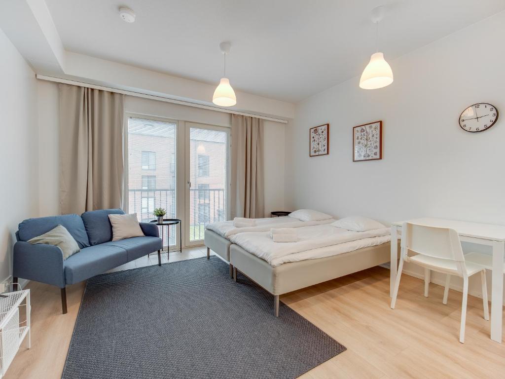 1 dormitorio con cama, sofá y ventana en SPOT Apartments - Turun satama, en Turku