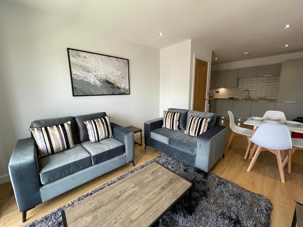 a living room with two couches and a table at Stylish and Modern 2BR Apartment with Parking in Sheffield