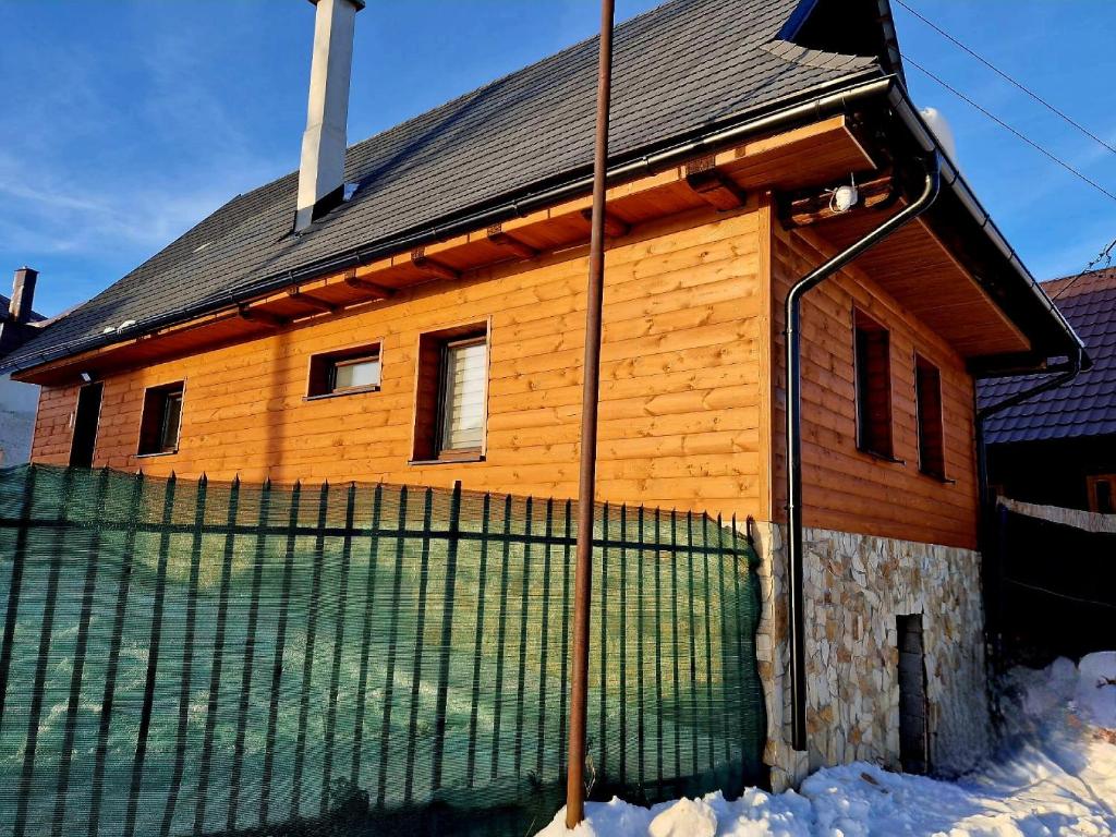 una casa in legno con una recinzione di fronte ad essa di Chata Štrbian Telgárt a Telgárt