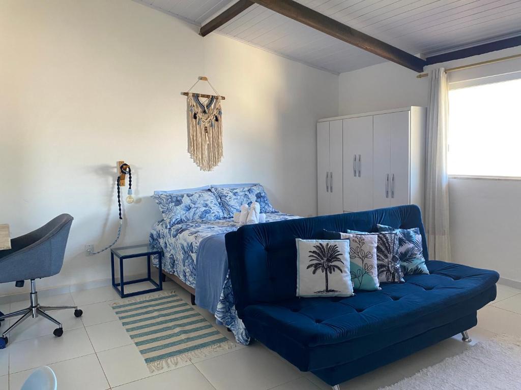 niebieską kanapę w sypialni z łóżkiem w obiekcie Loft Studio - MAR AZUL w mieście Lauro de Freitas