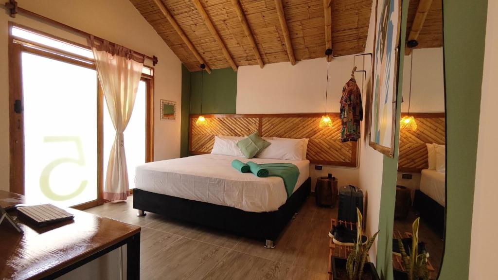 1 dormitorio con cama, escritorio y ventana en Puerto Bamboo, en Máncora