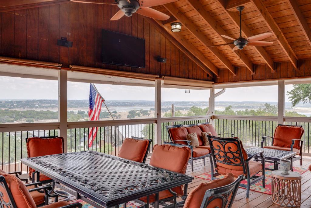 a screened porch with a table and chairs and a flat screen tv at Canyon Lake Home Hill Country and Water Views! in Canyon Lake