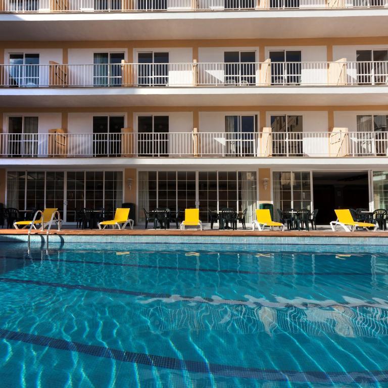a swimming pool in front of a hotel at Hotel Riutort in El Arenal