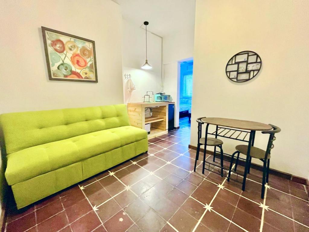 uma sala de estar com um sofá verde e uma mesa em Confortable Loft MN 960 B Centro Mty cerca de todo em Monterrey