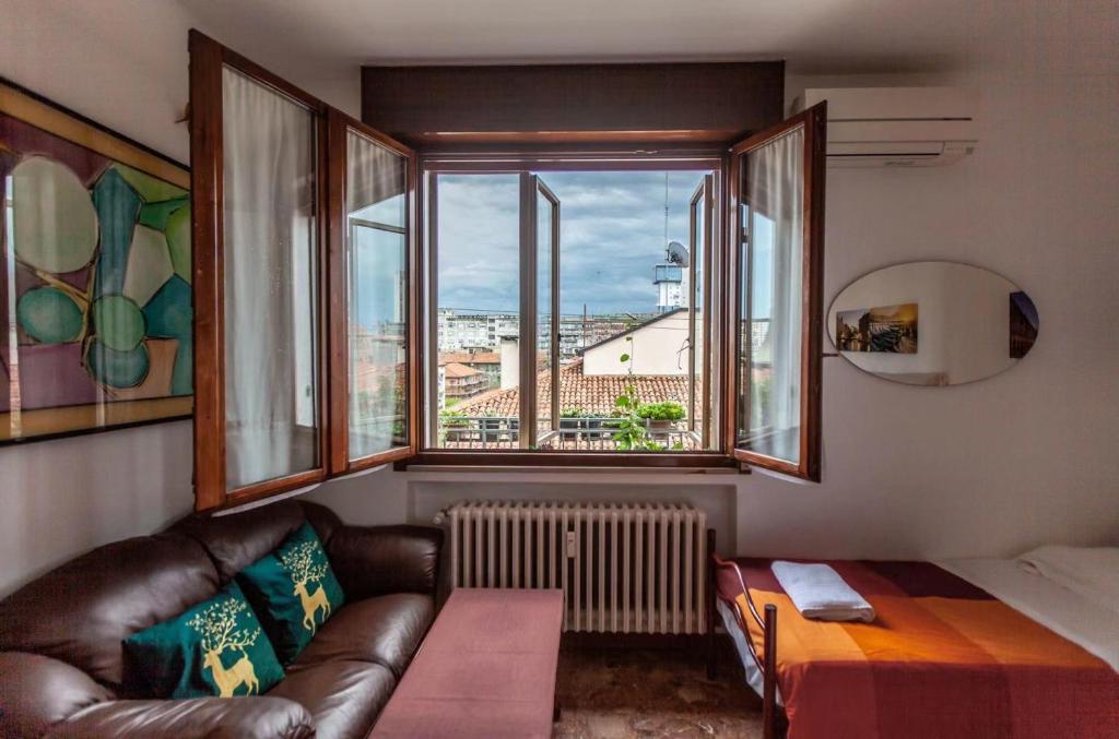 a living room with a couch and a large window at Sogna Venezia in Mestre