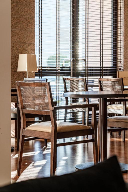 a room with tables and chairs and a large window at Hotel Dom Goncalo & Spa in Fátima