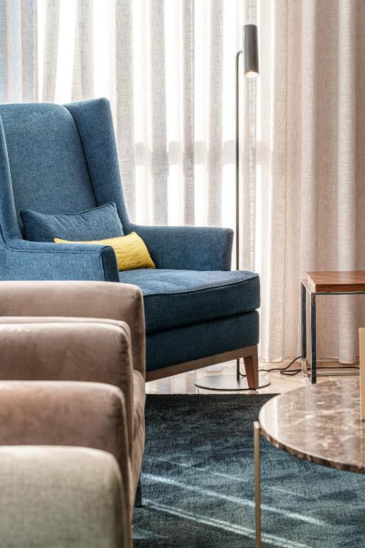 a living room with a blue couch and a table at Hotel Dom Goncalo & Spa in Fátima