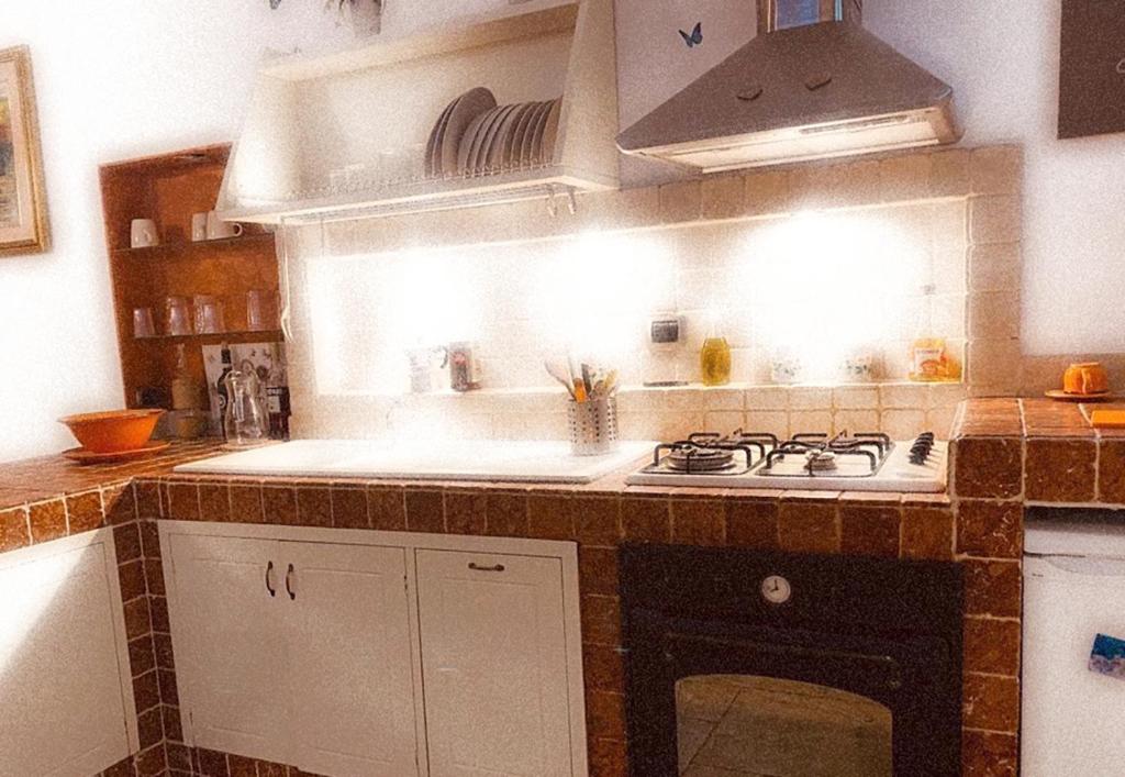 cocina con fregadero y fogones horno superior en L'antico Pozzo, en Sulmona
