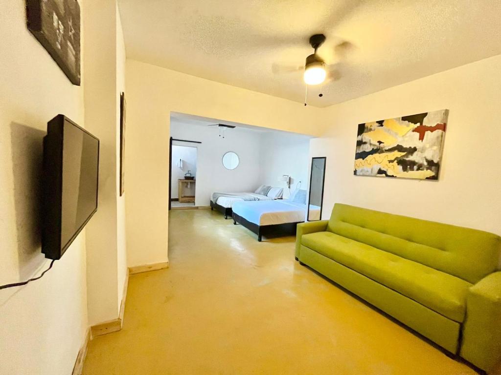 sala de estar con sofá verde y cama en Confortable Loft MN 960 C Centro Mty cerca de todo, en Monterrey