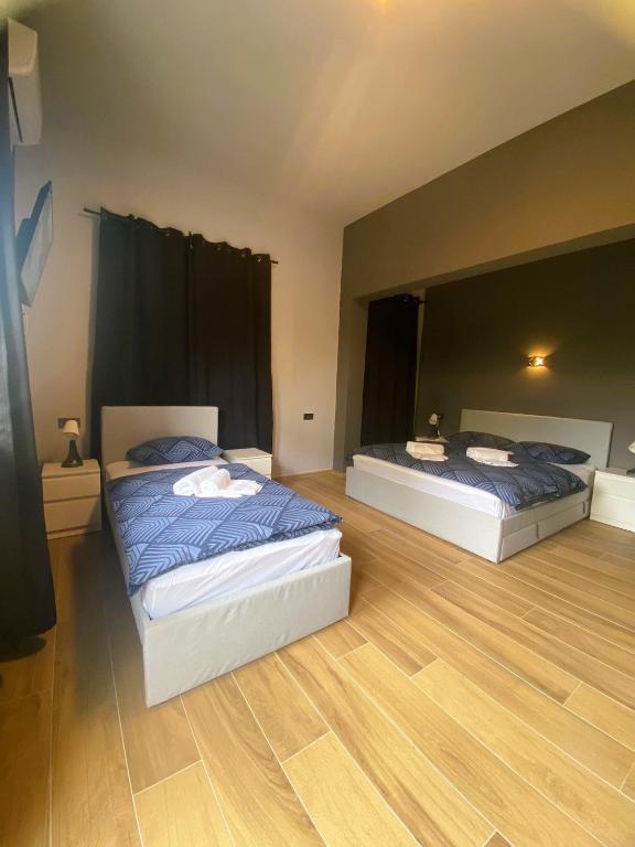 two beds in a large room with wooden floors at Rooms Matić 2 in Velika Mlaka