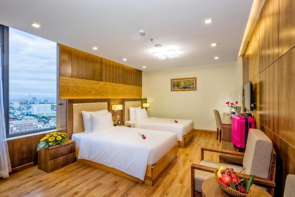 A two-bed room with a large picture window, city view and a long wood-finished wall.
